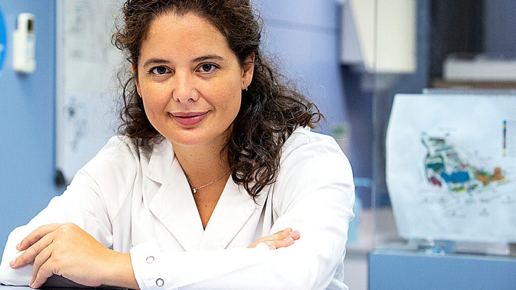 Portrait of a woman in lab coat, looking into the camera